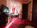 赤を基調とした最高級絨毯に黒をベースにしたサンダーソンのベッドカバーが挽きたつお部屋.