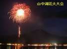 湖に反射する花火が美しく、背景には夏の富士山が浮かぶ