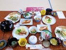 夕食の一例 赤魚の煮付け、真鯛とホタルイカの刺身、季節の天ぷら、うこぎの若葉ごはん、野沢菜漬けなど