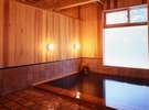 レンガ色のタイルと木のあたたかみを楽しむ浴室(写真：冨田治)