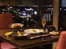 当館最上階のレストランで別府の夜景を見ながら、　オープンキッチンで仕上げるお料理がお楽しみ頂けます