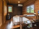 木のぬくもりに包まれた、SAWA棟のベッドルーム。窓からは柔らかな光が差し込みます。