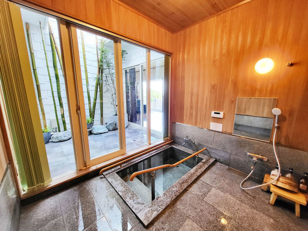 【1F/バスルーム】中庭と続いている石風呂は窓を開けると半露天風呂になります。