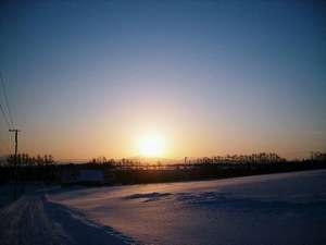 村から望む”オホーツク海に連なる知床の山並みから昇る　日の出　”
