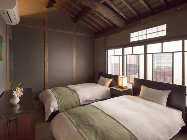 小屋裏と丸太梁が広がる寝室。町家の歴史を感じながら快適にお休み頂けます。