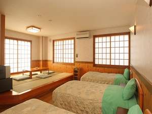 寛ぎの畳スペースと、ベッドが3台ある和洋室。グループやファミリーに人気