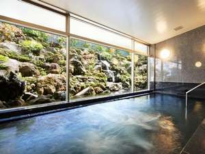 【大浴場（写真：男性用）】天寿石でできた浴槽。遠赤外線も高く体をポカポカ温めます。地下1階