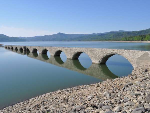 透き通った湖面にうつるアーチ型の橋がまるでメガネのようなタウシュベツ川橋梁