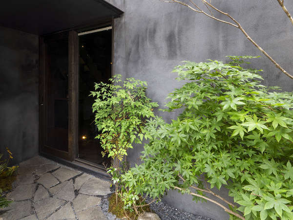 緑が植えられた玄関への石畳のアプローチ。夜になるとライトアップされ、幻想的な雰囲気に。