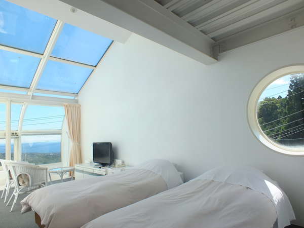 客室、ＤＸツイン。白を基調として、展望風呂と大きな天窓付き。