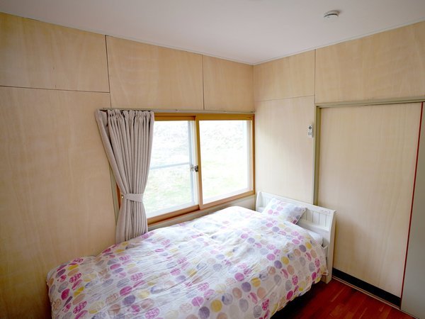 四畳半の洋室は、ベッドが２つ設置可能です。窓からは庭や木々が見え、清々しい眺めです。