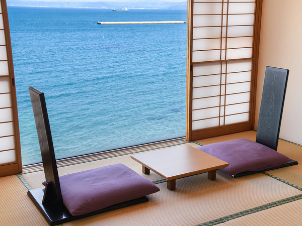 【特別室Aタイプ】　特別室の一角に設けられたガラス張りの休憩スペース、一面に真っ青な海と空が広がる。