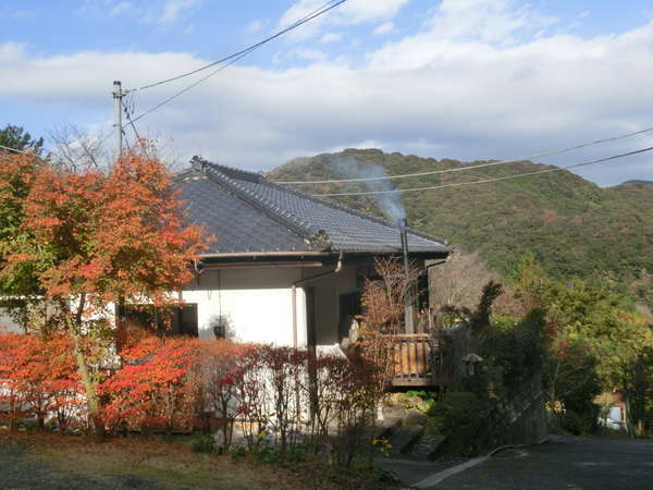 晩秋の宿外観.里山の中腹の森の中にぽっかりとたたずむ一日一組限定の一棟貸切・露天風呂付温泉宿です。