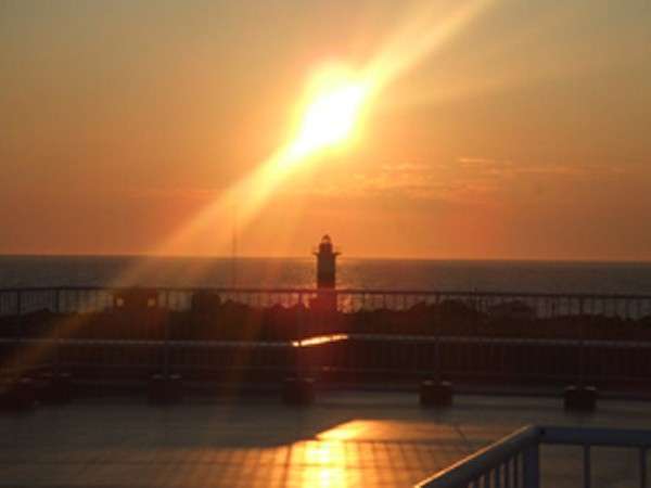 ホテル利尻展望屋上から眺める夕陽と沓形灯台