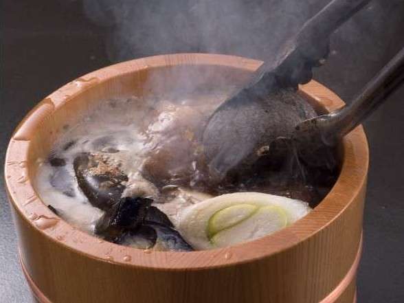 光雲荘名物！目の前で焼けた石を入れる石焼き樽。