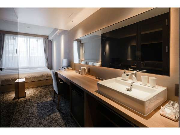 ツインルーム：壁一面の鏡が特徴的な洗面スペース