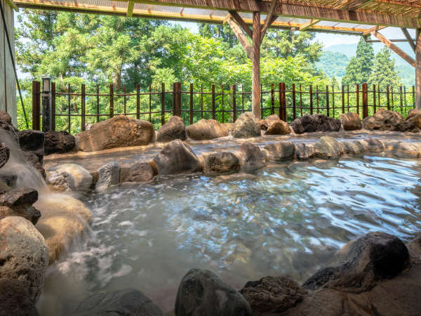 【露天風呂一例】四季折々に異なる里山の景色を望むワイルドな岩露天風呂です。
