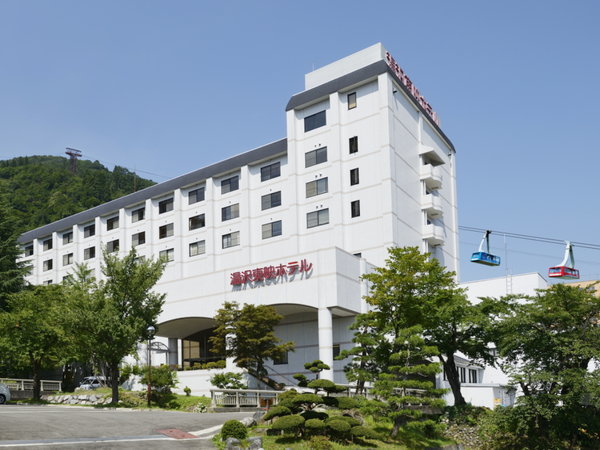 【ホテル外観】greenシーズンの湯沢東映ホテル。エネルギッシュな緑に包まれる。