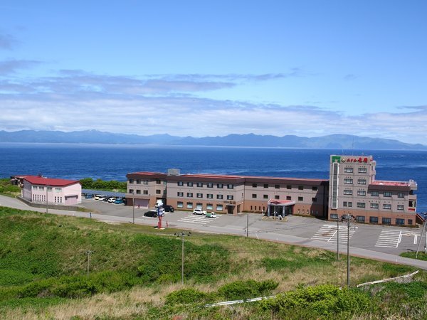 ホテル外観。背景に見える山並みは北海道です。