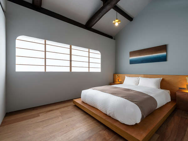 2階にはダブルベットの置かれた寝室が2部屋。和紙のアート、古い梁などが和の落ち着きを感じさせる空間。