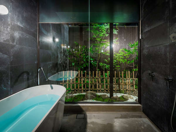 坪庭の緑を間近に、ゆったりとバスタイムが楽しめる浴室。夜はライトアップされた庭の景色が楽しめます。