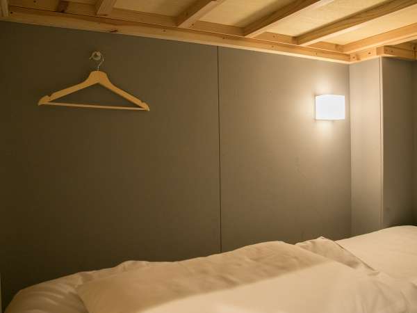 プライバシーカーテンと個別の読書灯が備わるドミトリールームのベッド1台分です。