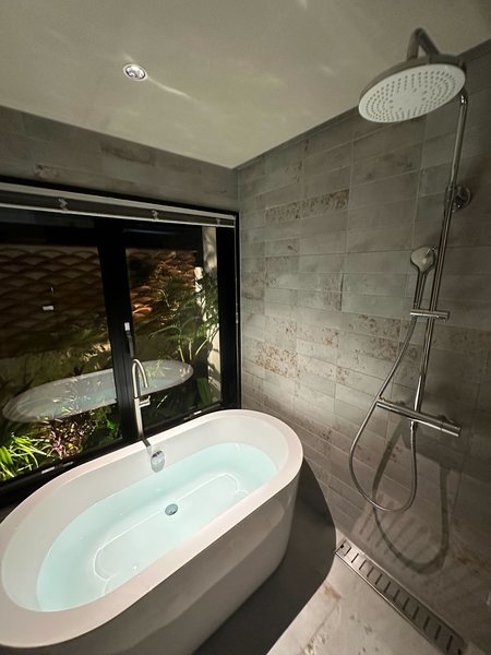 【浴室】熱帯植物がバランスよく配置された坪庭を望みながらバスタイムを愉しむ事ができます。