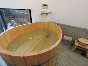 ひのき風呂と床に天然青石「十和田石」を使用した贅沢な浴室