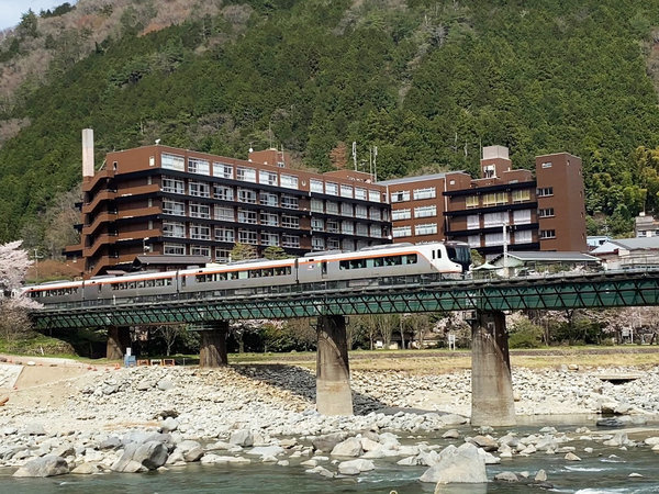 春の全景と飛騨川を渡るJR高山線の新車両