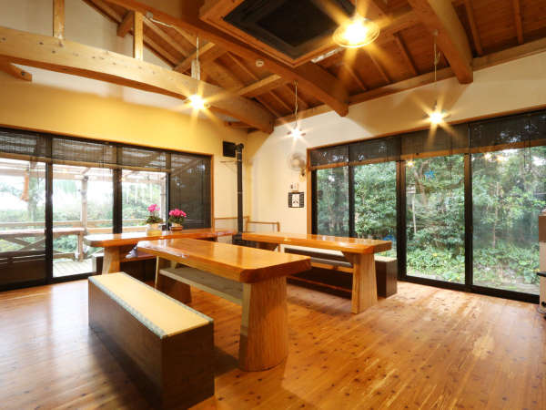 【食事処】屋久島の杉で作られたテーブル。窓からは晴天の日には森の向こうに太平洋が見えます。