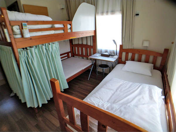 ・【本館 1～3名個室】二段ベッド＋シングルベッドのお部屋。トイレとユニットバス、49型テレビも設置