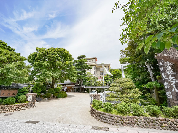 『外観』長楽園の看板と「温泉龍大プール」の大きな切り株が目印です