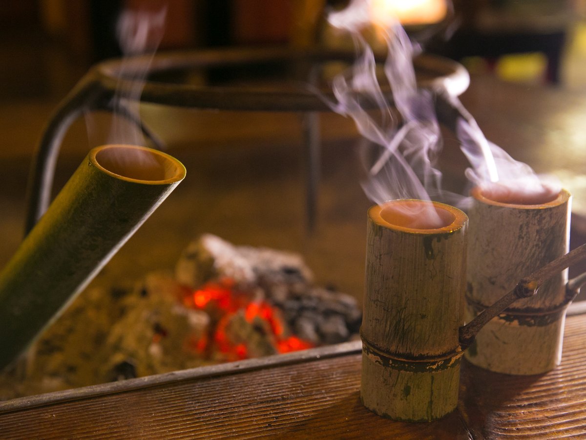 【館内施設】囲炉裏を囲んでいただく闊歩酒。青竹の油分が酒にしみ出て独特の風味に、笑顔がこぼれます。
