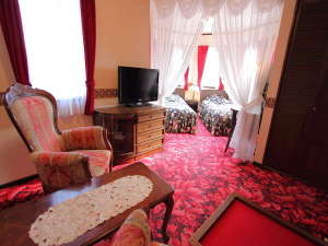 赤を基調とした最高級の絨毯に黒をベースにしたサンダースのベッドカバーがよく映えるお部屋。