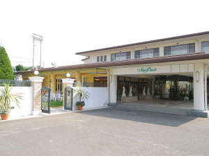 「サンパーク吉井」の広々とした駐車場と緑豊かな落ち着いたホテルです