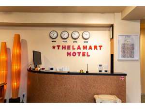 「ＴＨＥ　Ｌ．Ａ．ＭＡＲＴ　ＨＯＴＥＬ　ＫＹＯＴＯ」の世界時計を壁に配したフロントカウンター