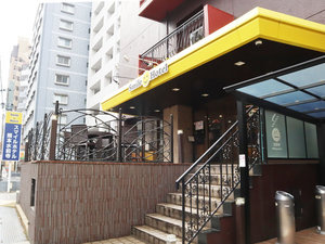 「スマイルホテル熊本水前寺」のホテル外観。黄色の看板、茶色の建物。新水前寺駅より徒歩3分！