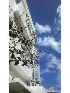 「民宿たつや旅館　沖縄那覇店」の青空に映える白壁のビルです