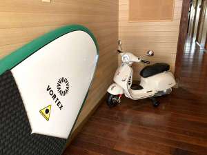 「ゲストハウス＆ダイビング　シーコロ」のSUPとVespa(模型)が皆さんをお出迎え