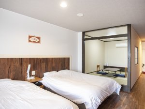 【客室一例】広々としたベッド２台に、畳６畳のスペースがあり、伸び伸びとお寛ぎいただけます。