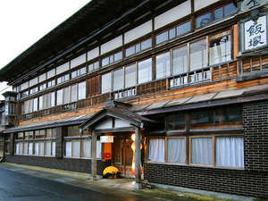 「飯塚旅舘」の*古き良き時代を感じさせる木造建築の当館外観。