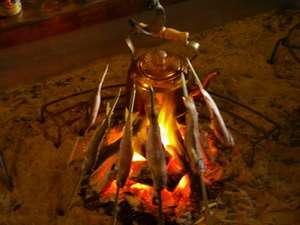 「信州の隠れ宿　まほろば」の囲炉裏を囲んでイワナの炭火焼き