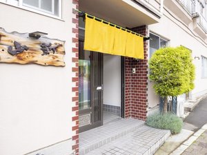 「民宿山新」の玄関　のれんが目印です。