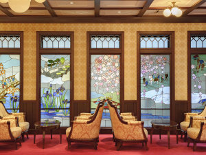 「金沢白鳥路　ホテル山楽」の【ロビーラウンジ】ステンドグラスの柔らかな光が優雅で非日常のひとときに誘います。