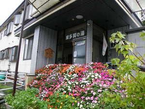 「旅館　東多賀の湯」の春から秋の玄関前は花いっぱいでお迎えいたします。