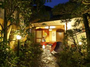 「天然温泉100%の3種の無料貸切風呂の宿　山水荘」の木々に囲まれた情緒ある玄関。