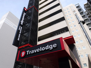 「トラベロッジ名古屋栄」の外観：赤と黒の建物、Travelodgeを目印にしてください