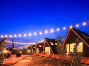 「TENT　Ichinomiya　GlampingResort」の三角屋根のキャビンが6棟の中庭は夜になると幻想的にライトアップ。