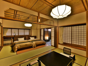 「温泉露天客室」のお部屋（美松亭）の一例。二間続きの和室にベッドがあり、源泉かけ流しの露天風呂付