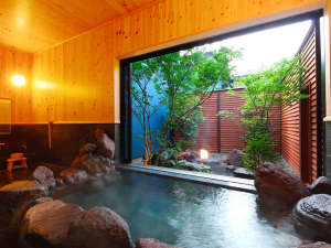 【文(ぶん)】檜の壁がやさしく香る内湯には個性豊かな石々で組まれた赴き深い岩風呂。